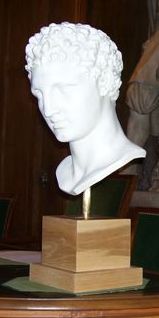Copie de la tête de l’Hermès d’Olympie offerte par le ministre de la culture de la République hellènique, le 21 mars 2007, aux Académies des Beaux-arts et des inscriptions et belles-lettres