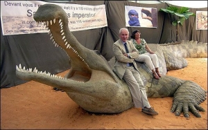 Philippe Taquet pose avec une reconstitution de Sarcosuchus imperator crocodile préhistorique d’une douzaine de mètres.