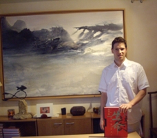 Yann Hendgen, à son bureau, posant devant une oeuvre de Zao Wou-Ki